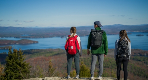 College students overlooking a lake from the top of a mountain
