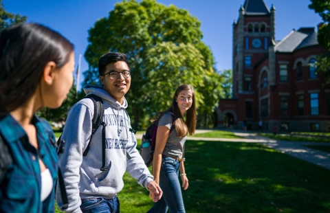 Three college students walking across campus