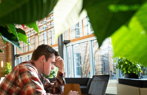 A student stares intently at his laptop screen