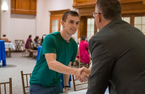 Photo of two men shaking hands over a table