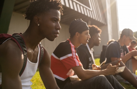 Photo of four college students sitting in the sun
