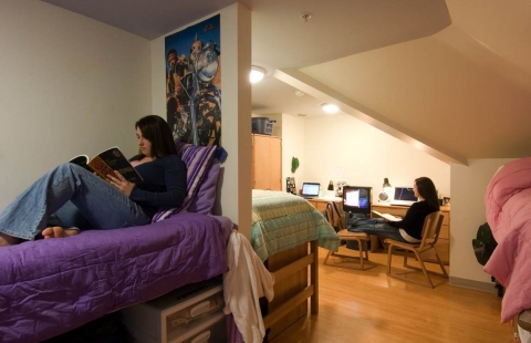 Two female college students reading in their dorm room