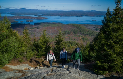 Three college students climbing a mountain
