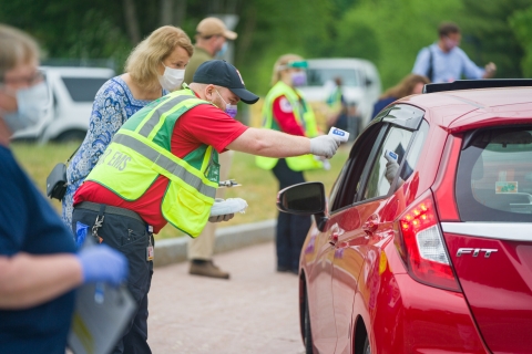 A photo of a volunteer taking the temperature of a NH State House Representative