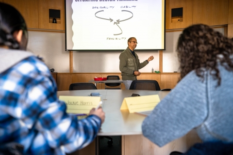 A photo of two female college students listening to a professor present