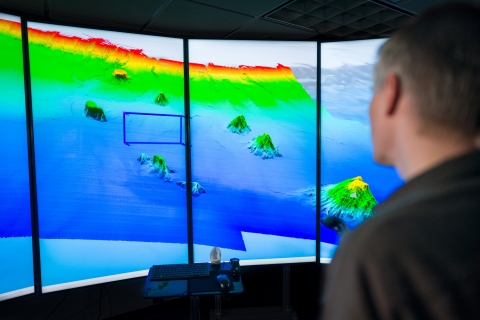 Photo of scientist looking at data visulation map of the ocean